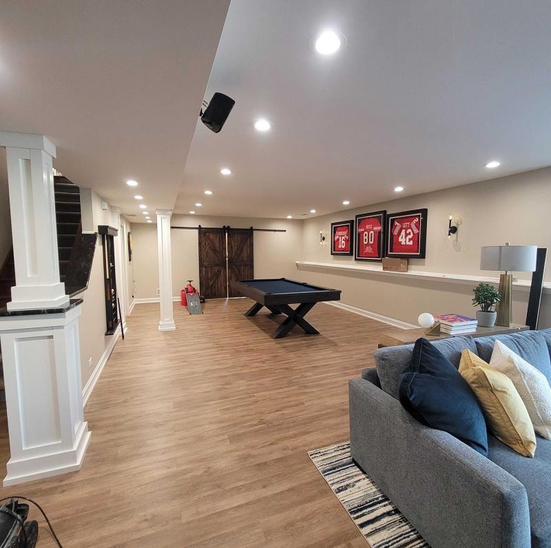 SilverBullet basement finish — open entertainment suite with pool table, barn door, and LVP flooring