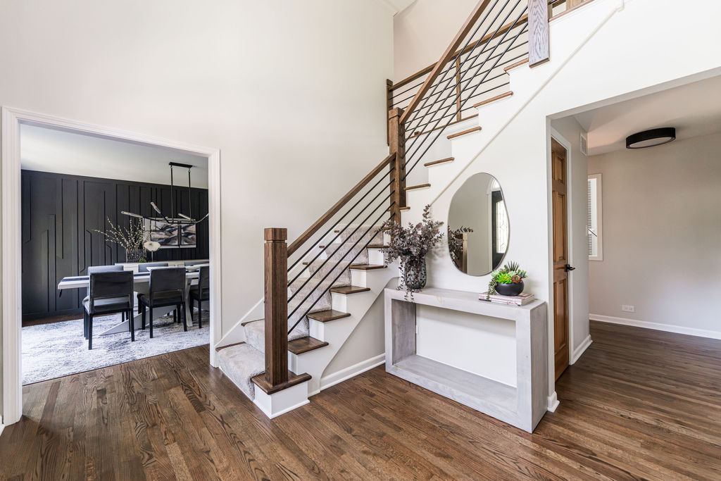 Alyssa Naperville — staircase and foyer detail showing dark wood newel posts and horizontal iron rail system