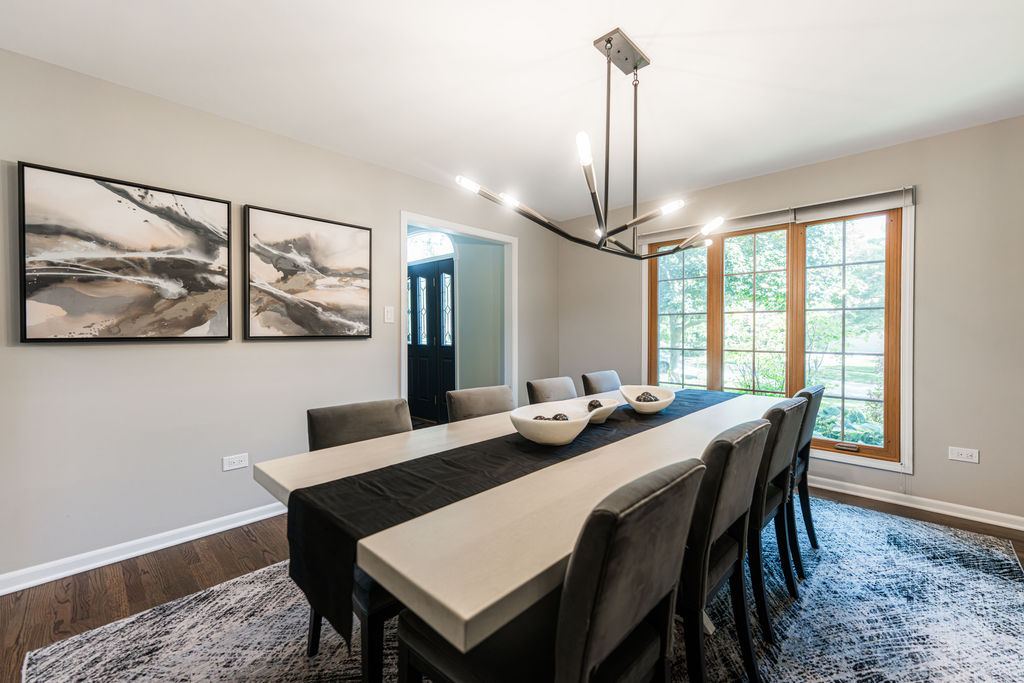 Alyssa Naperville — formal dining area with high-contrast white and charcoal palette and large windows with natural light