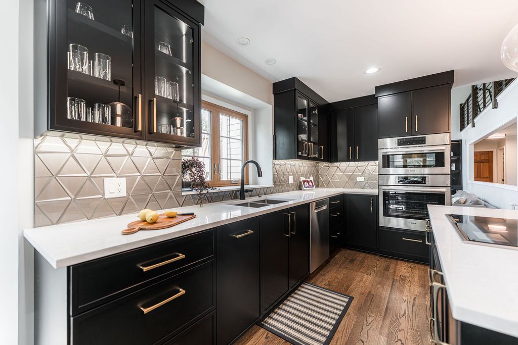 Alyssa Naperville kitchen — all-black cabinetry with glass uppers, gold pulls, white quartz countertops, and Bosch appliance suite
