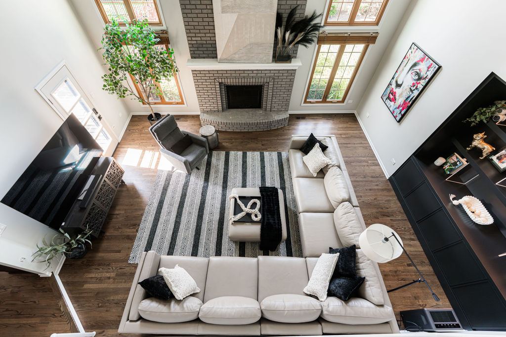 Alyssa Naperville — great room aerial view showing open plan layout, dark hardwood floors, and fireplace focal point
