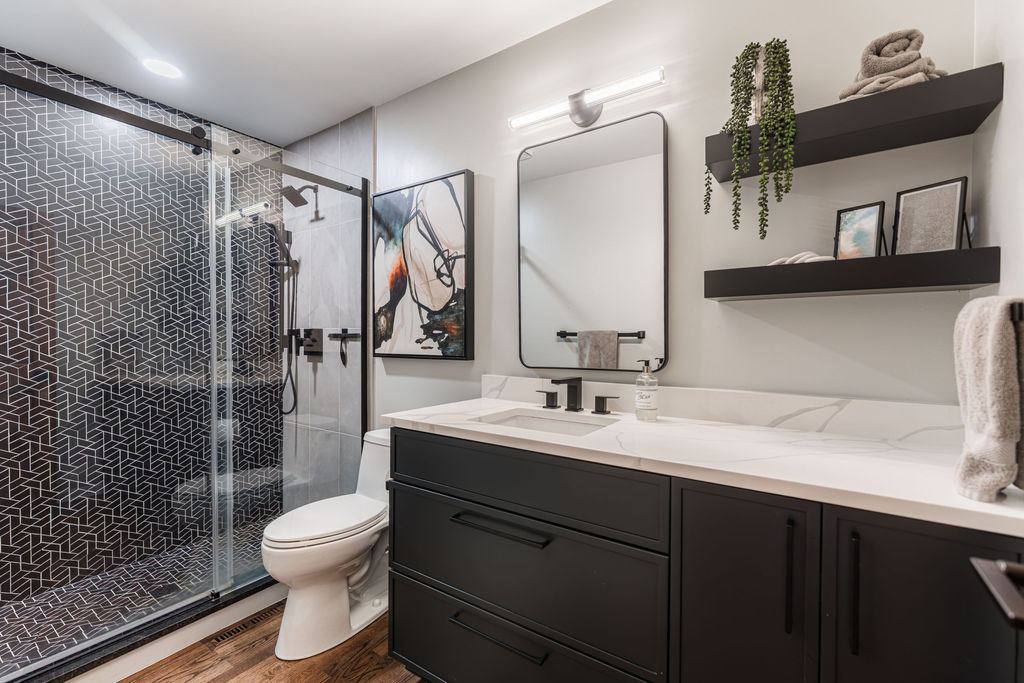 Alyssa Naperville — secondary bathroom with matte black vanity, white quartz countertop, black-framed mirror, and floating shelves