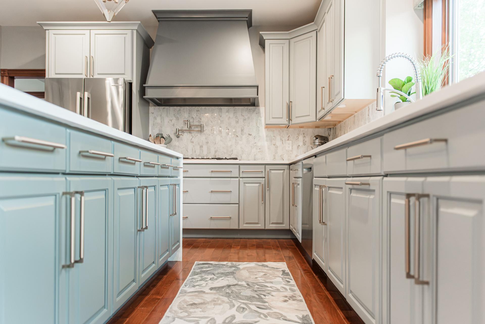 Cooking wall — gray painted range hood, marble mosaic backsplash, gas cooktop with pot filler, sage island — Bealer kitchen remodel Geneva IL