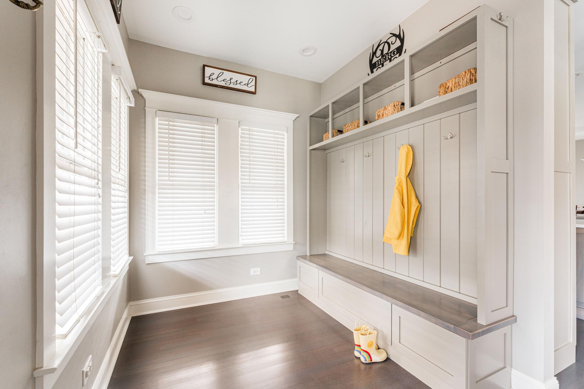 Custom mudroom — built-in locker system with cubbies, coat hooks, storage bench, and upper shelving — Dillman whole-home remodel Plainfield IL
