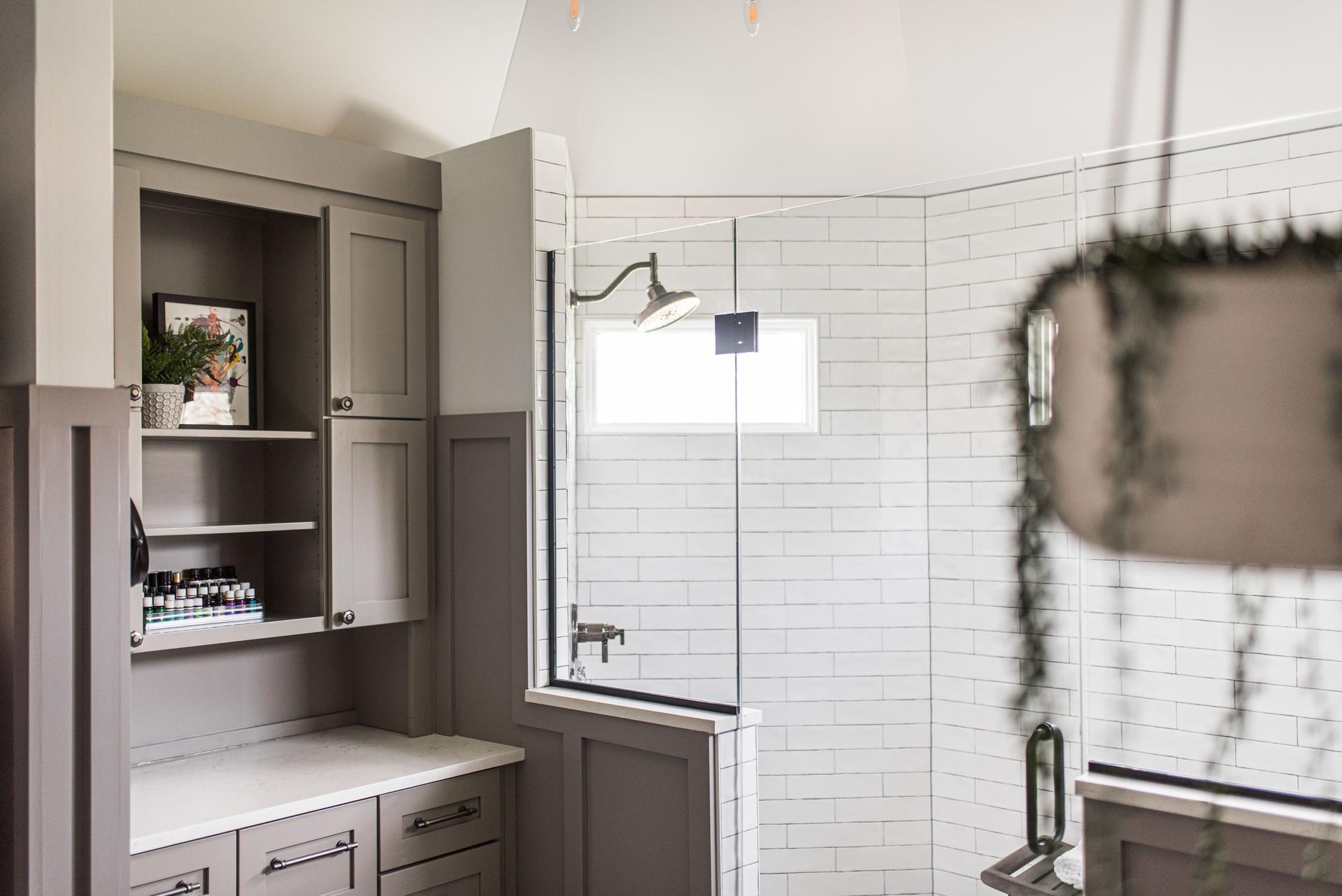 Shower entry and built-in bathroom cabinetry with open shelving — Dillman primary bath Plainfield IL