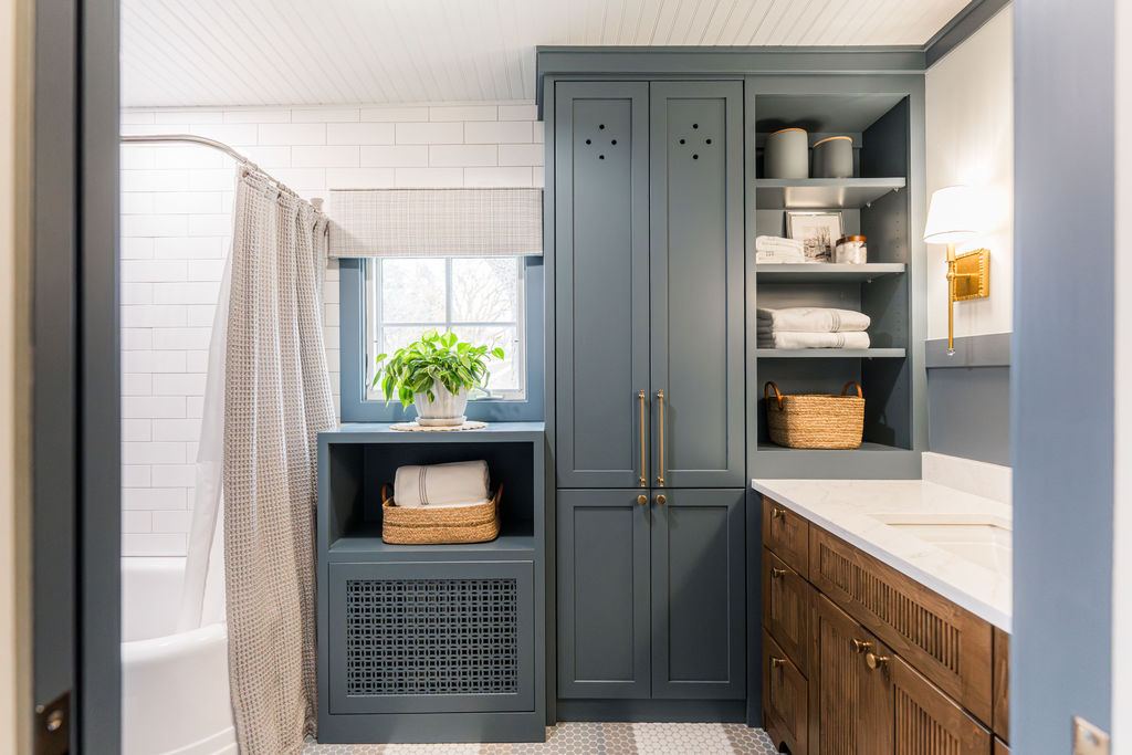 Fulton Geneva — shared bathroom with slate blue painted linen tower, hex tile, and warm walnut vanity