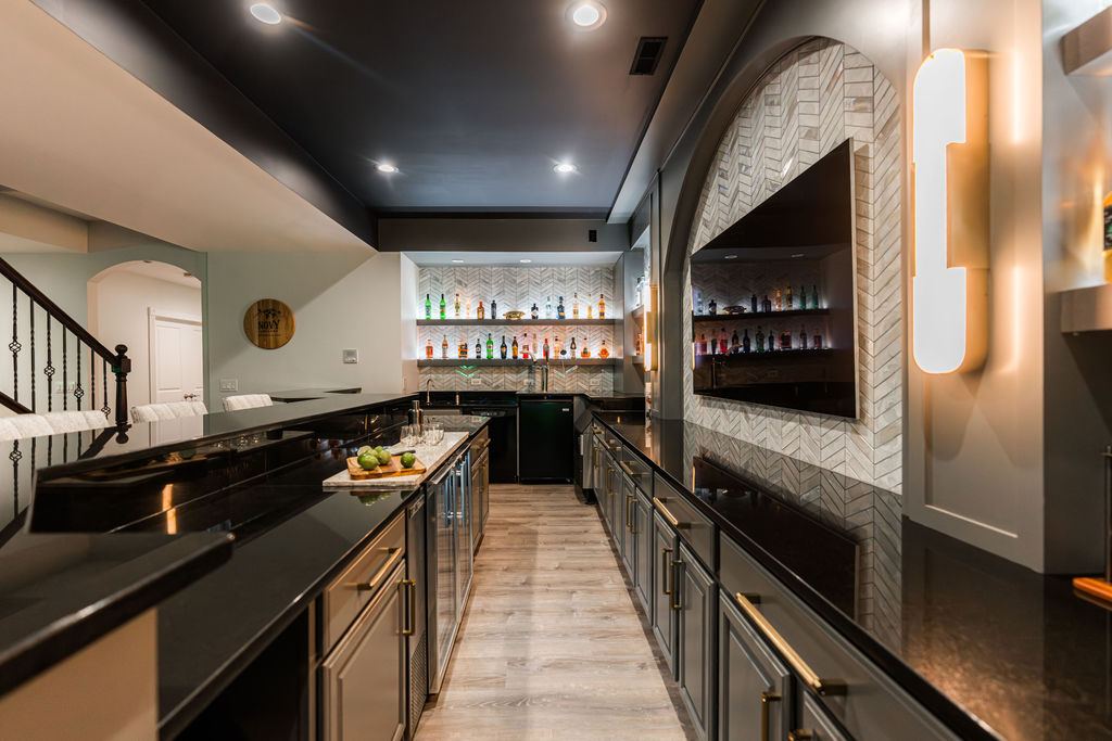 Hickory St. Charles — bar detail showing black granite countertop with brass hardware and illuminated bottle display