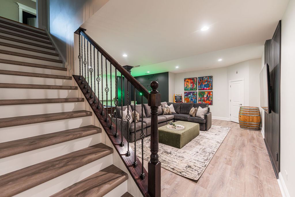 Hickory St. Charles — lounge area with grey sectional, neon sign on dark accent wall, and green lighting