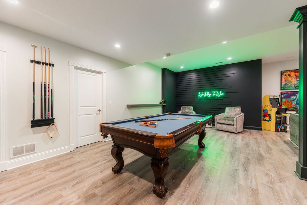 Hickory St. Charles — billiards room with pool table, green neon 'We Play To Win' sign, arcade cabinet, and cue wall rack