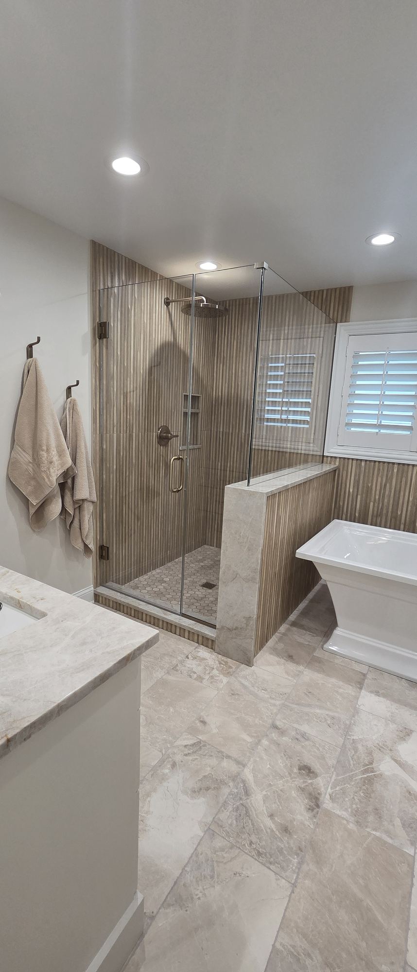 Park Ridge primary suite remodel — frameless glass shower, freestanding tub and fluted wood-look tile — Park Ridge IL