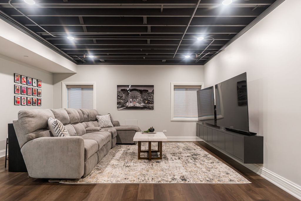 Yorkshire Oakbrook — lounge area with art gallery wall and black exposed joists ceiling